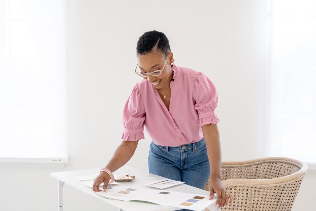 Chelsea Quenum, Northern Virginia wedding planner, reviewing design swatches at a desk.