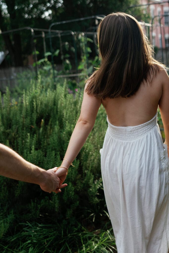 Engaged couple holding hands in a garden in Northern Virginia, captured during a romantic engagement session.