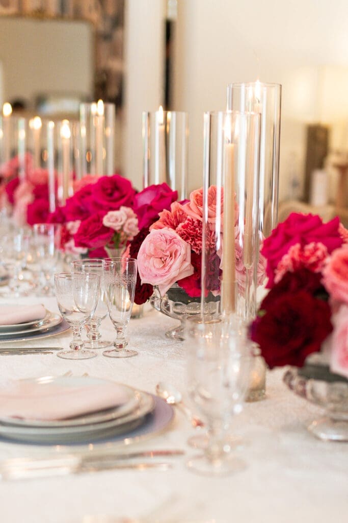 Bright pink and red florals, embroidered linens, and glassware from a Modern Parisian wedding editorial at Swann House, designed by Chelsea Quenum Wedding Planning & Event Design.