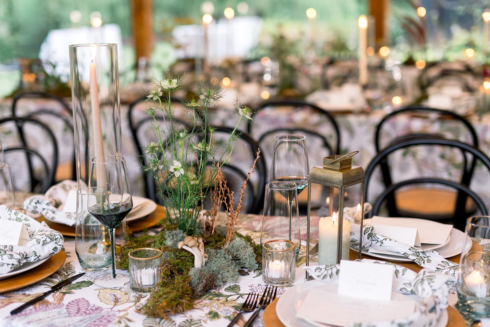 Reception table set for a Northern Virginia wedding with patterned linens, candlelight, layered place settings, and floral centerpieces in a warmly lit reception space.