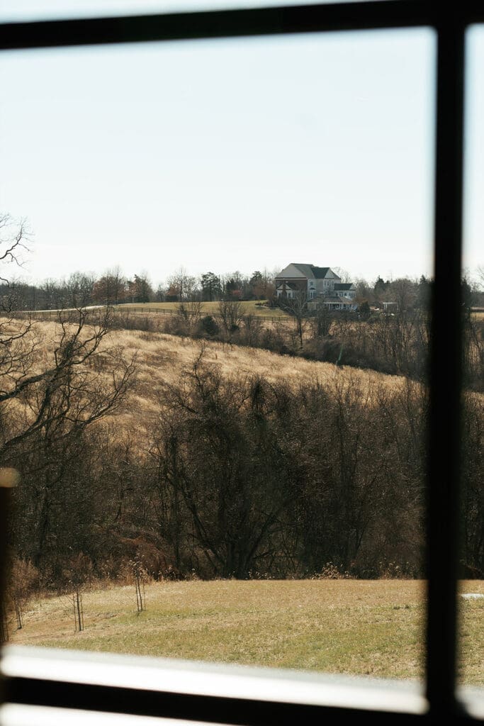 View from inside Manor 1858 looking out over rolling fields and the surrounding Loudoun County countryside.